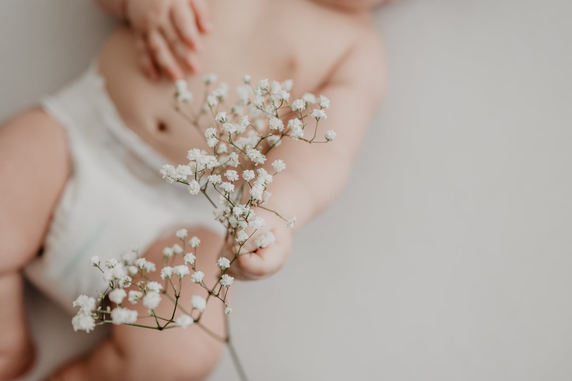 baby touching delicate flowers